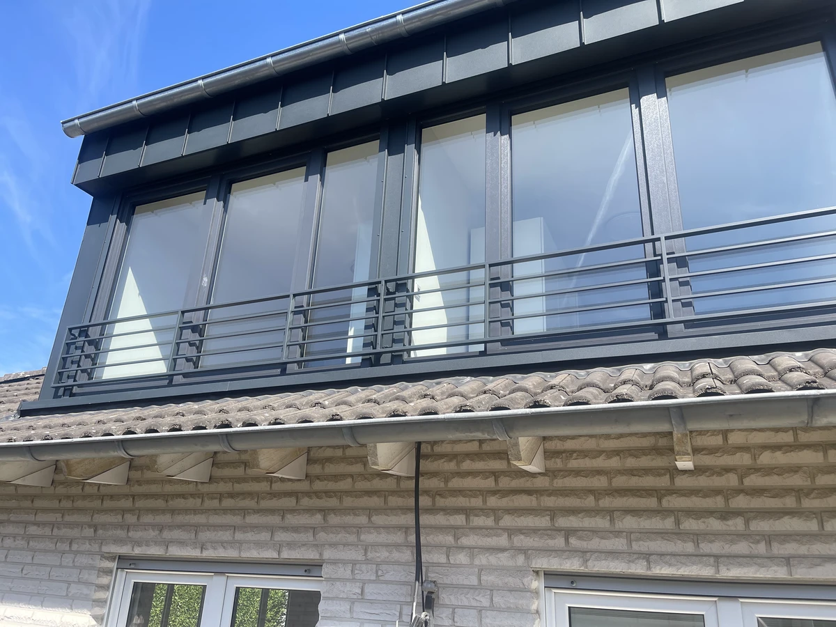 Schwarzer französischer Balkon mit Edelstahlgeländer an einem modernen Dachausbau