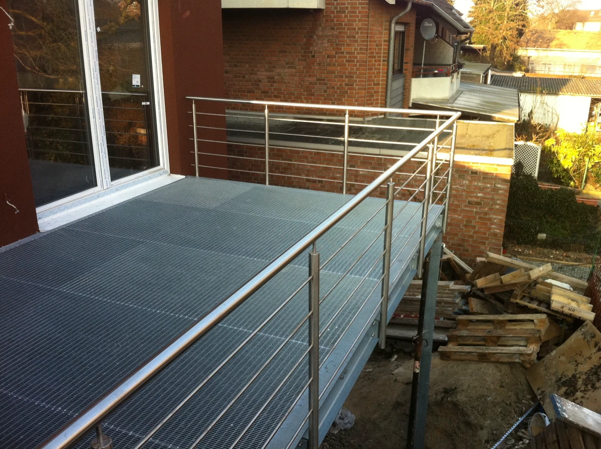 Stahlkonstruktion als Balkonplattform mit Edelstahlgeländer und Gitterrostbelag