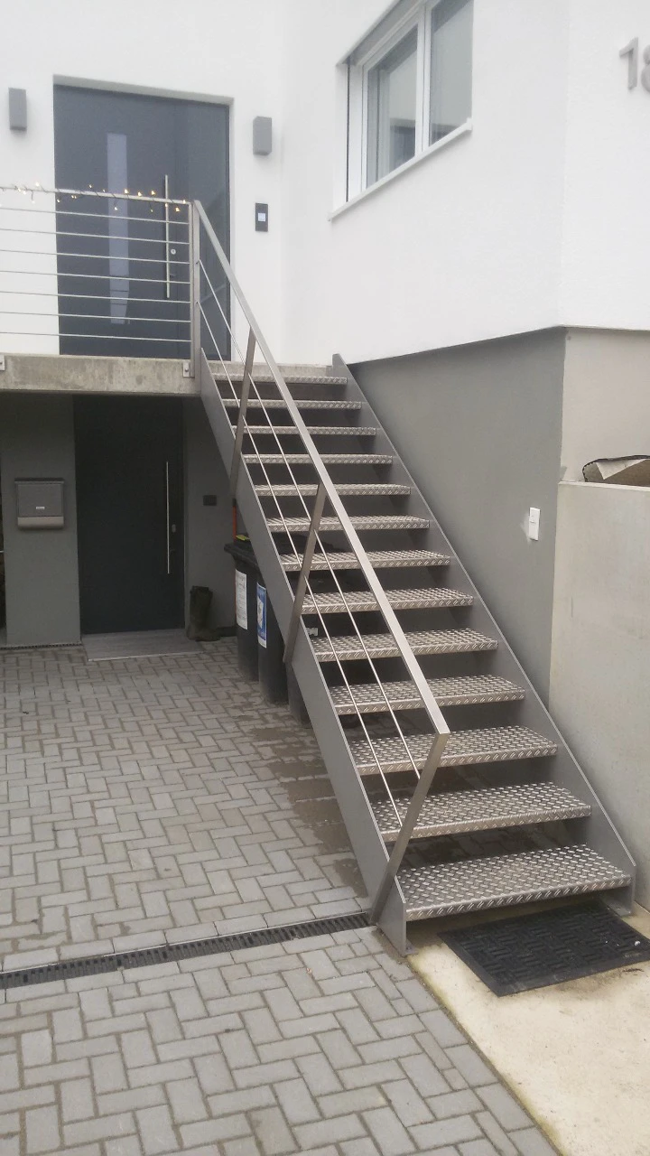 Außentreppe aus Edelstahl mit gelochten Stufen und schlichtem Geländer